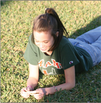Permaglow1 Junior, Grace Kimmel, lies on the green outside of the library to catch some rays on a sunny day.
